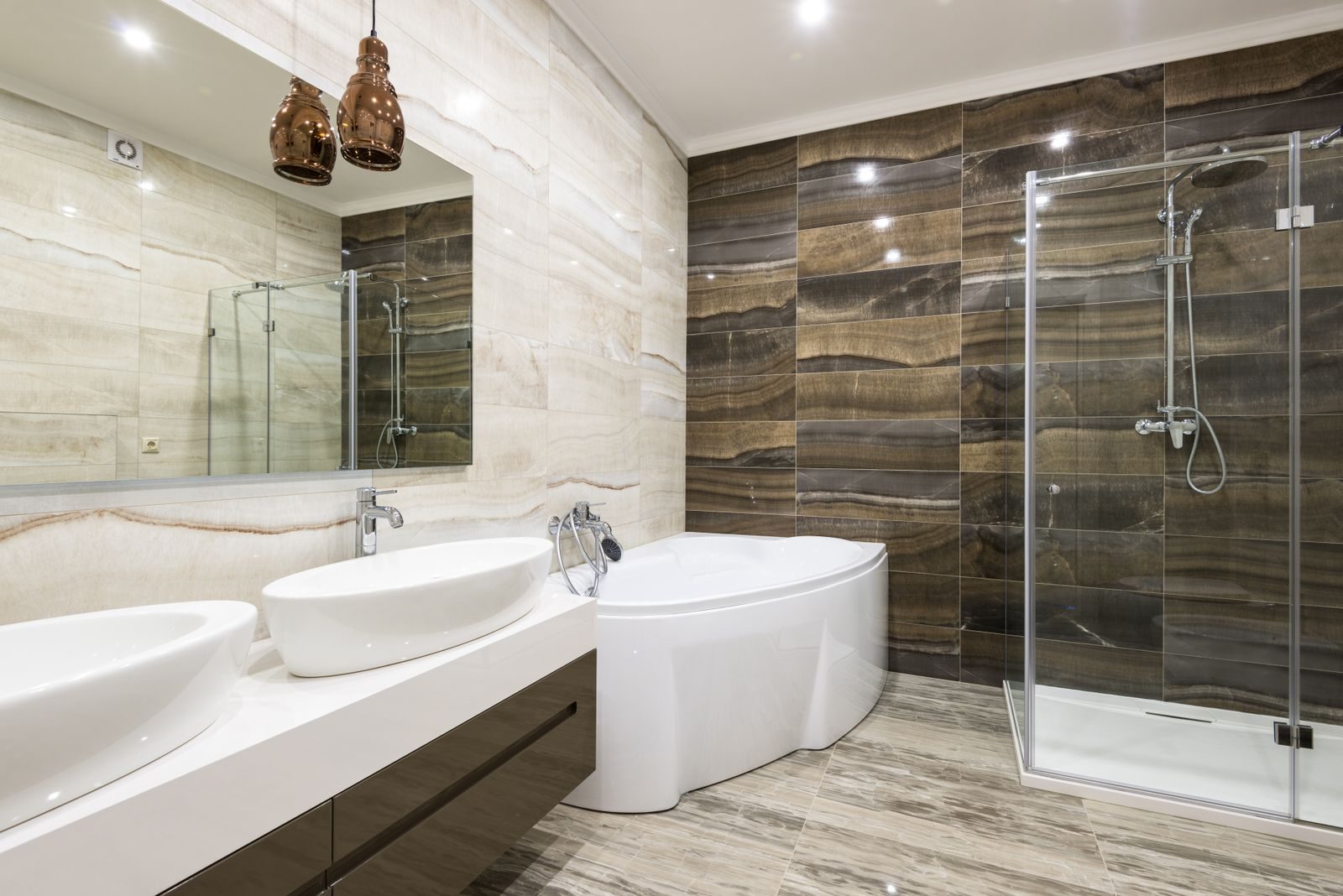 A designer bathroom with double basins, bath and shower