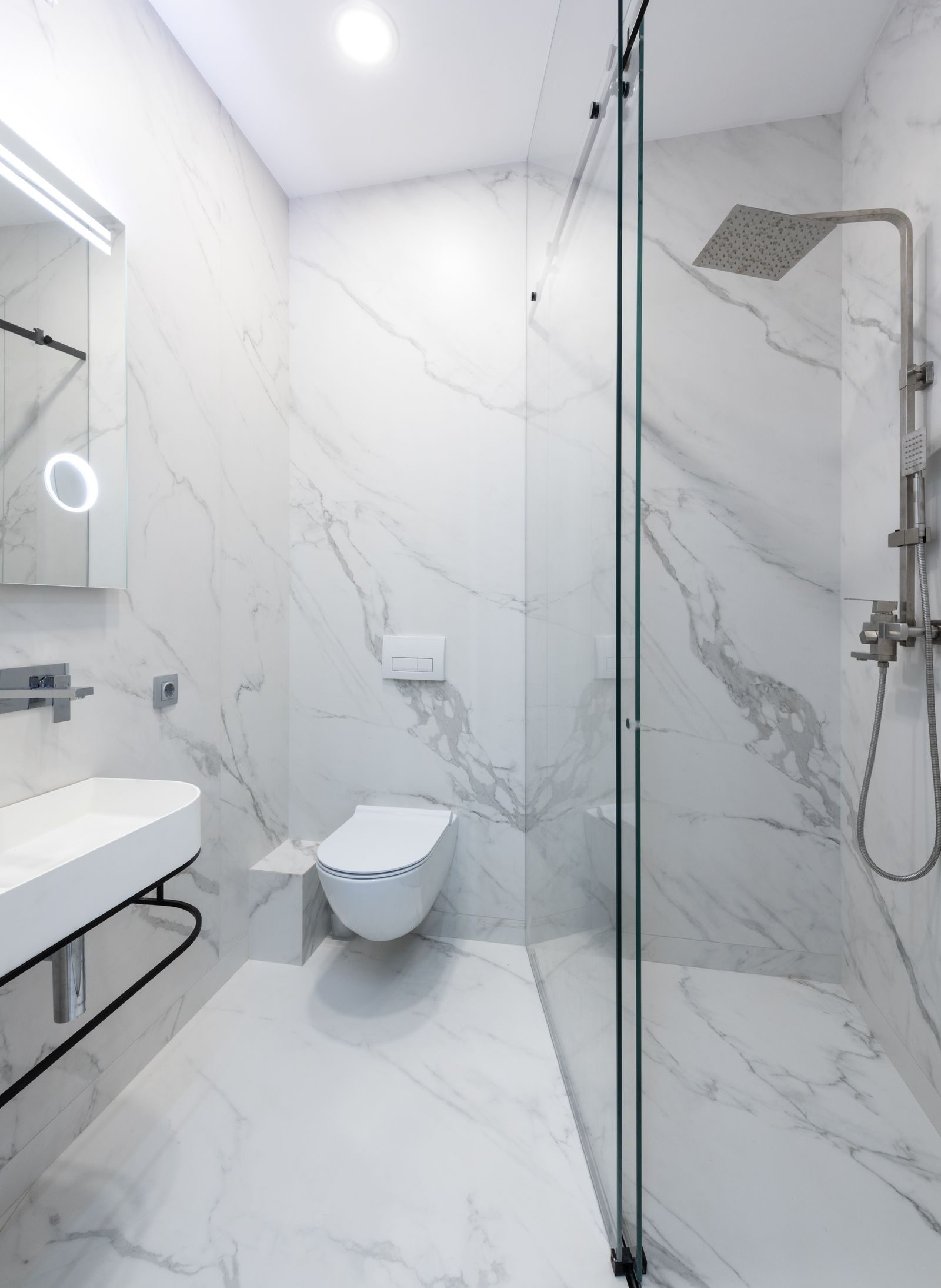 A compact white marble en-suite with walk-in shower